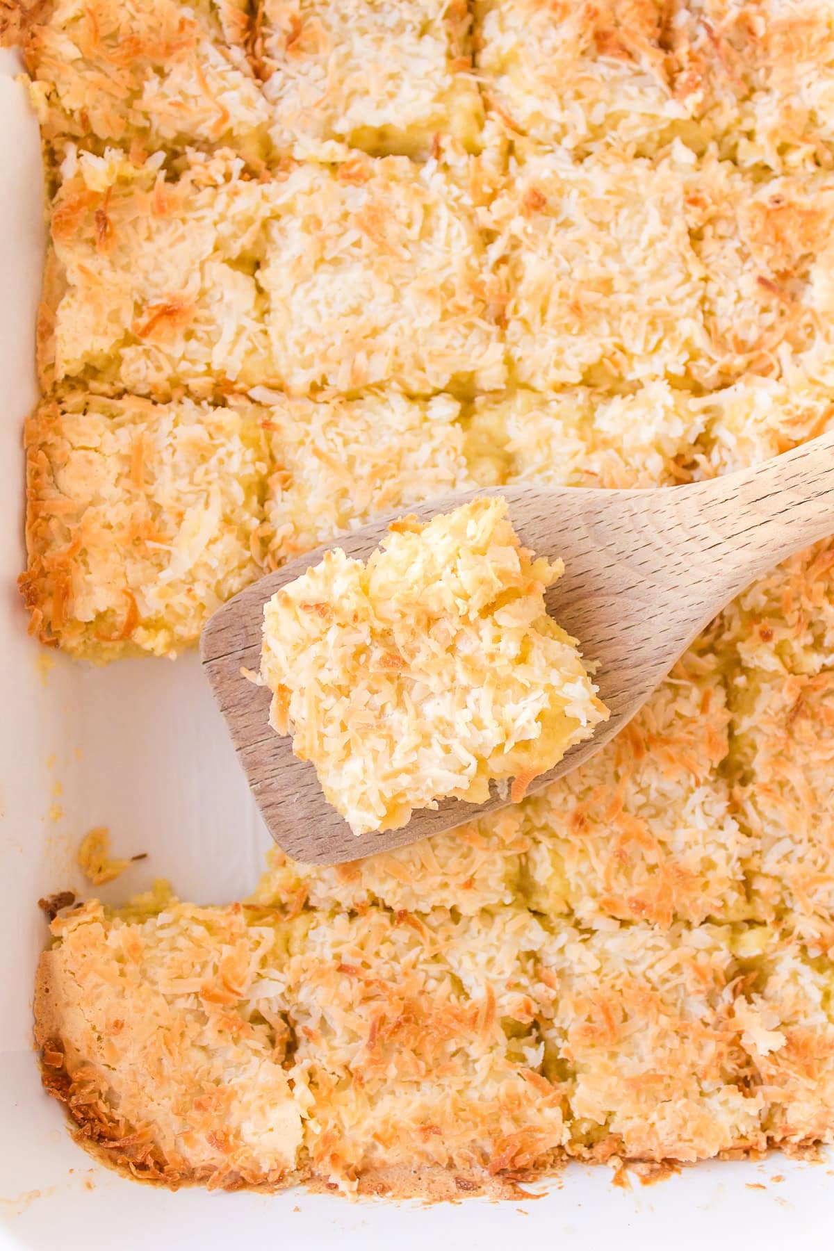Almond Coconut Bars recipe from RecipeGirl.com spatula taking almond coconut bar out of pan of bars