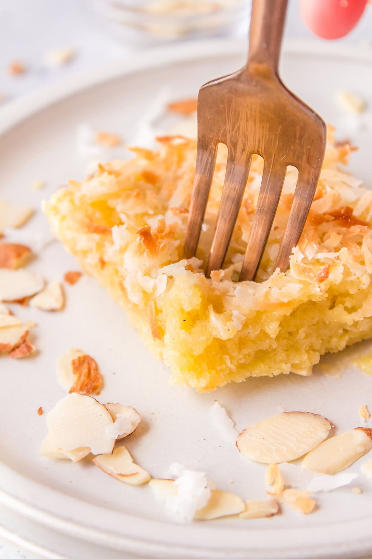Almond Coconut Bars recipe from RecipeGirl.com fork stuck into an almond coconut bar