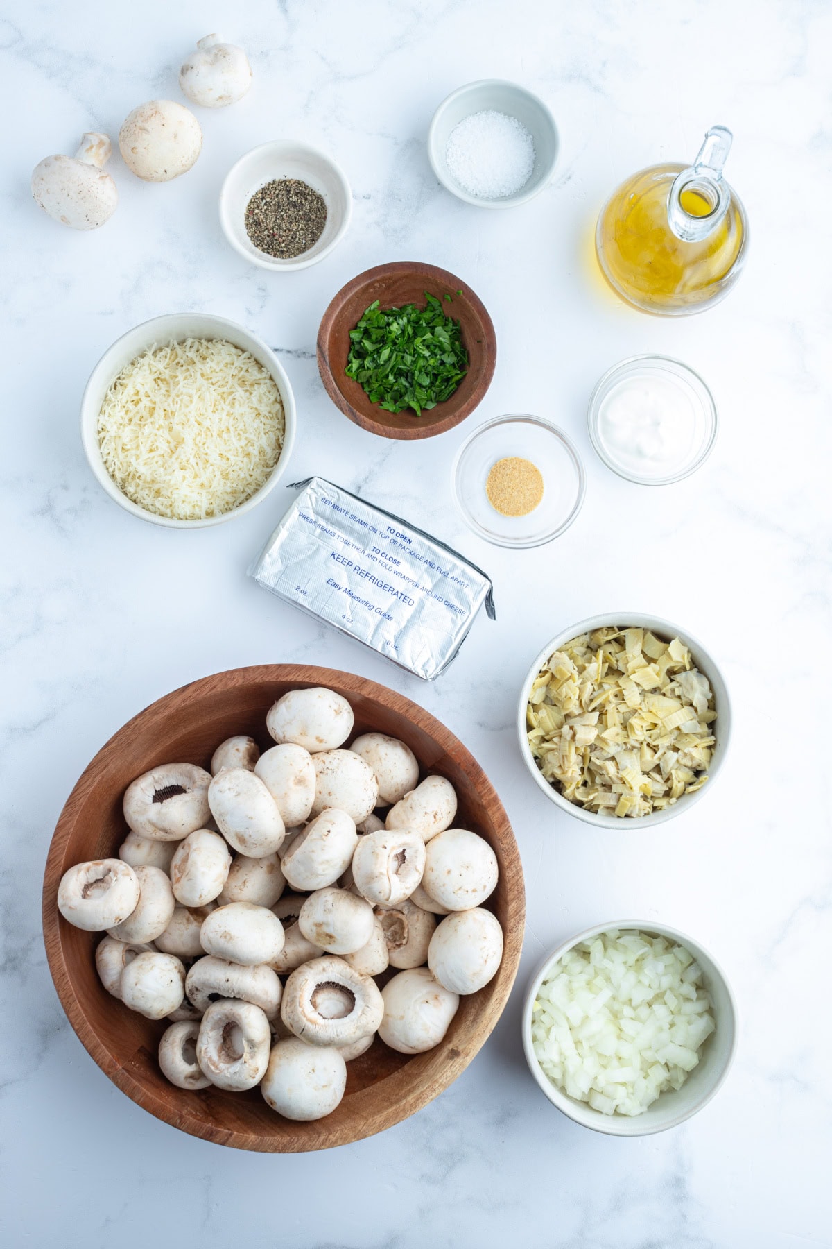Artichoke Stuffed Mushrooms recipe from RecipeGirl.com ingredients displayed for making artichoke stuffed mushrooms