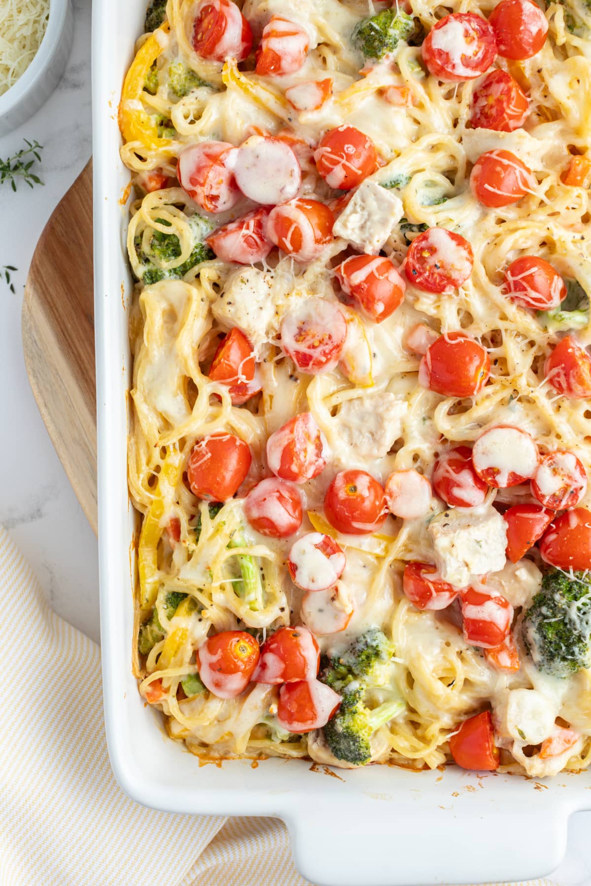 Baked Lemon Chicken Spaghetti Primavera recipe from RecipeGirl.com half view of baked lemon chicken spaghetti primavera in baking dish