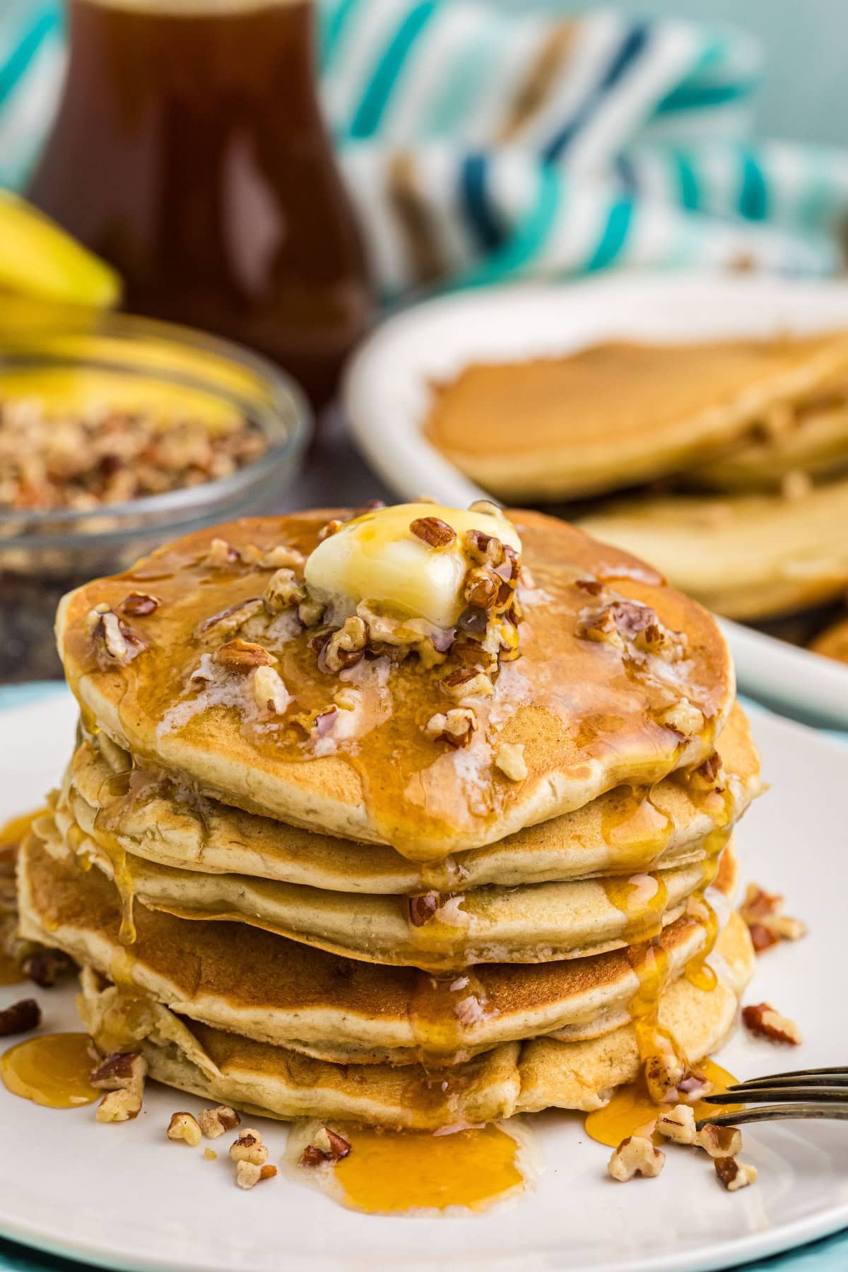 Banana Pecan Pancakes recipe from RecipeGirl.com // easy breakfast and brunch recipe stack of banana pecan pancakes with butter and syrup