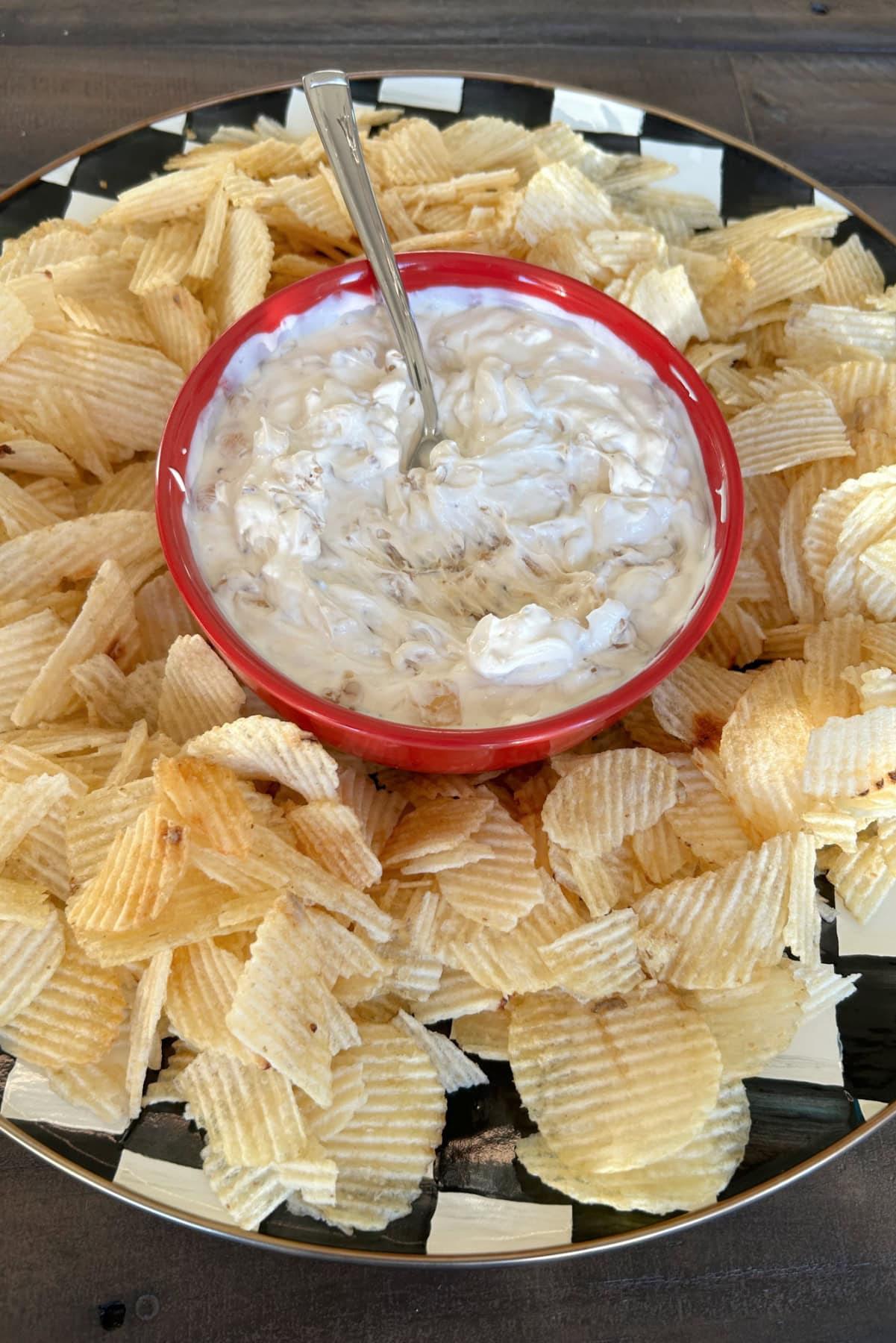 Caramelized Onion Dip recipe from RecipeGirl.com red bowl of caramelized onion dip on platter with potato chips