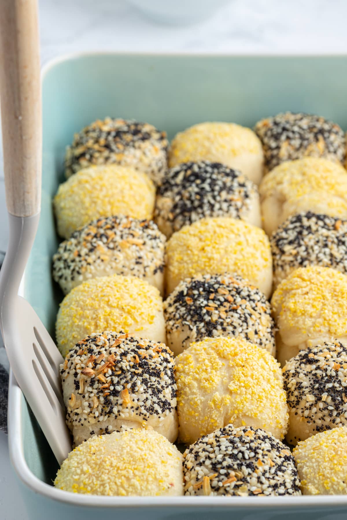 Checkerboard Dinner Rolls recipe from RecipeGirl.com spatula taking out checkerboard dinner roll in baking dish