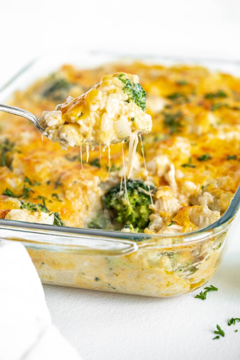 Cheesy Chicken and Broccoli Rice Casserole recipe from RecipeGirl.com #cheesy #chicken #broccoli #rice #casserole #recipe #RecipeGirl spoonful of chicken and rice casserole lifting out of dish