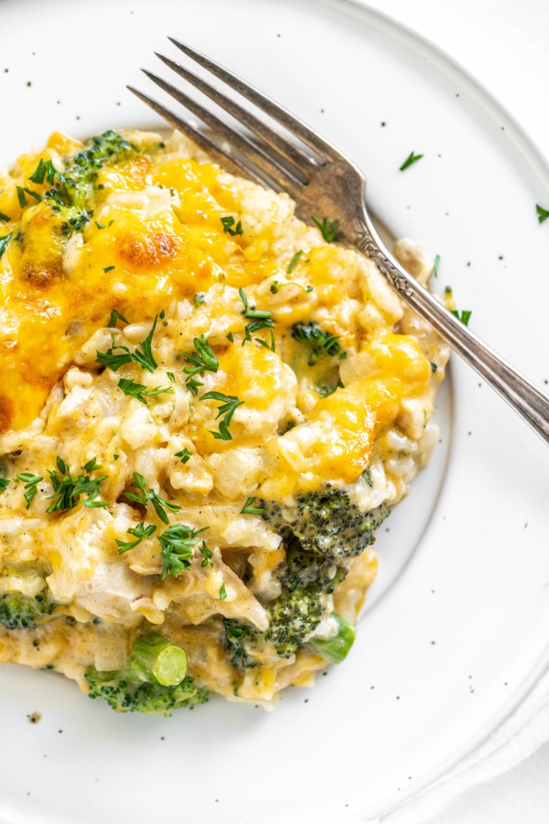 Cheesy Chicken and Broccoli Rice Casserole recipe from RecipeGirl.com #cheesy #chicken #broccoli #rice #casserole #recipe #RecipeGirl serving of chicken and broccoli rice casserole on a plate with a fork