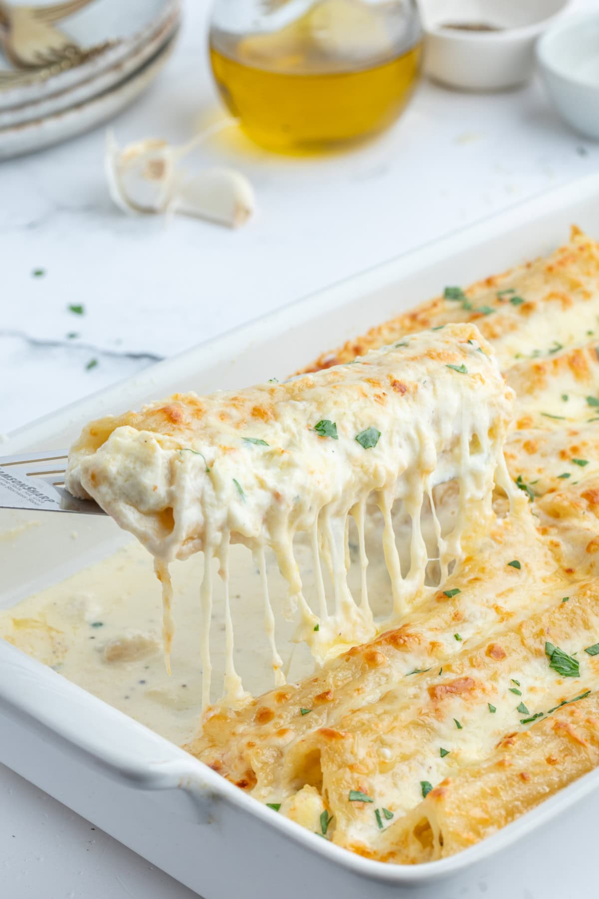 Chicken Manicotti Alfredo recipe from RecipeGirl.com : best stuffed manicotti : chicken manicotti : cheese manicotti : cheesy pasta recipe! spatula lifting up chicken manicotti alfredo out of pan