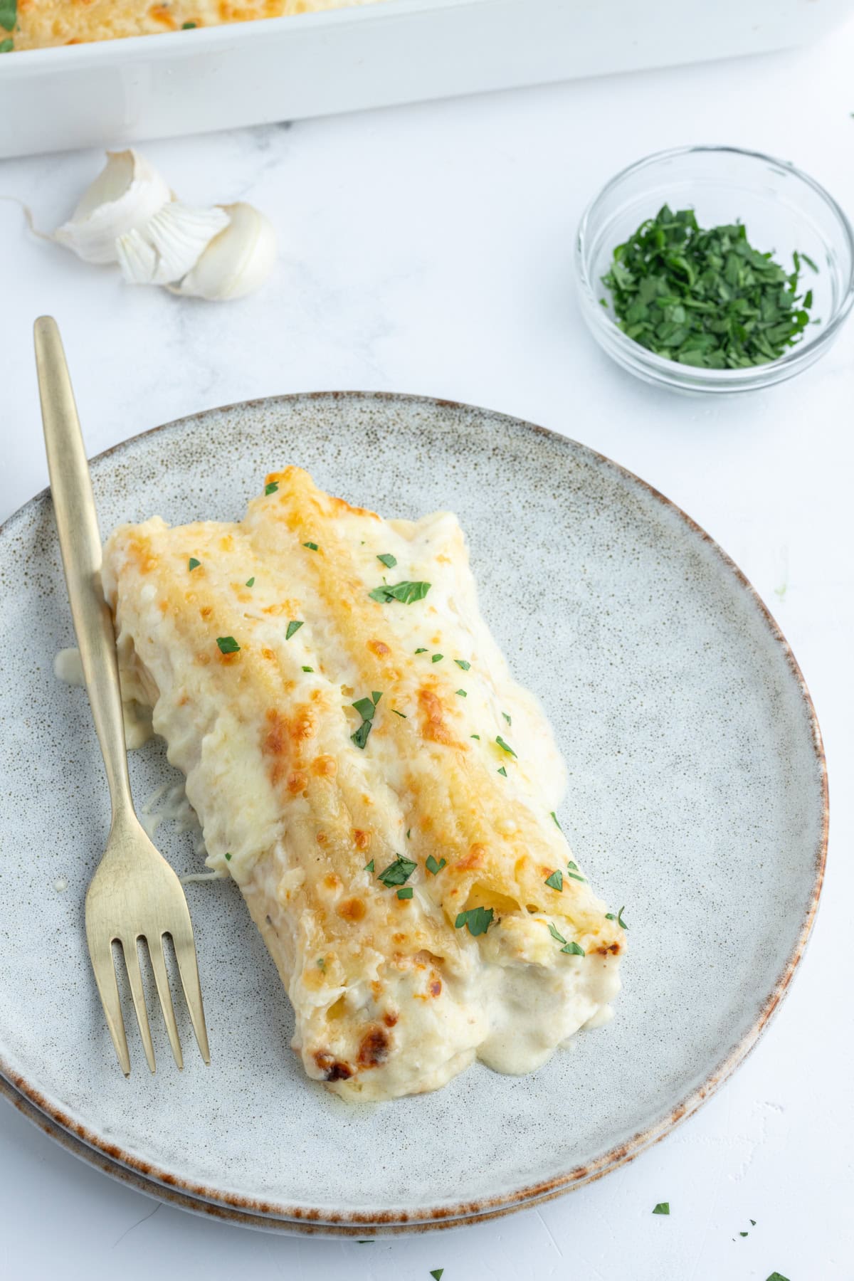 Chicken Manicotti Alfredo recipe from RecipeGirl.com : best stuffed manicotti : chicken manicotti : cheese manicotti : cheesy pasta recipe! serving of chicken manicotti alfredo on plate with fork