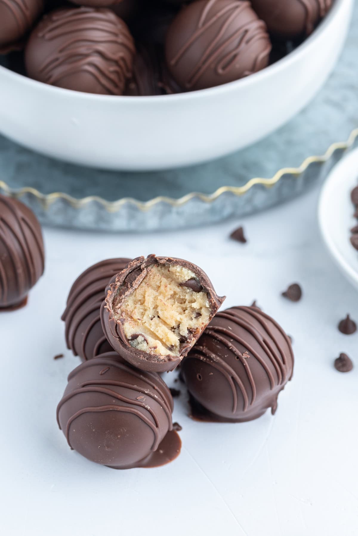 Chocolate Chip Cookie Dough Truffles recipe from RecipeGirl.com flour safe to eat : chocolate covered chocolate chip cookie dough lovers a few chocolate chip cookie dough truffles with one bite taken out
