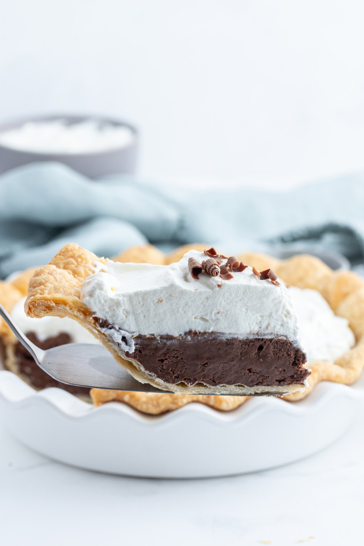Totally delicious classic easy Chocolate Cream Pie recipe from RecipeGirl.com spatula holding up slice of chocolate cream pie