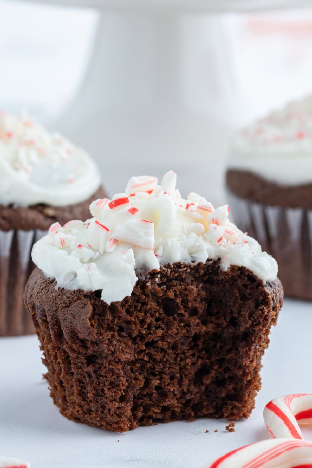 Chocolate Cupcakes with Peppermint Icing recipe from RecipeGirl.com chocolate cupcakes with peppermint icing with bite taken out