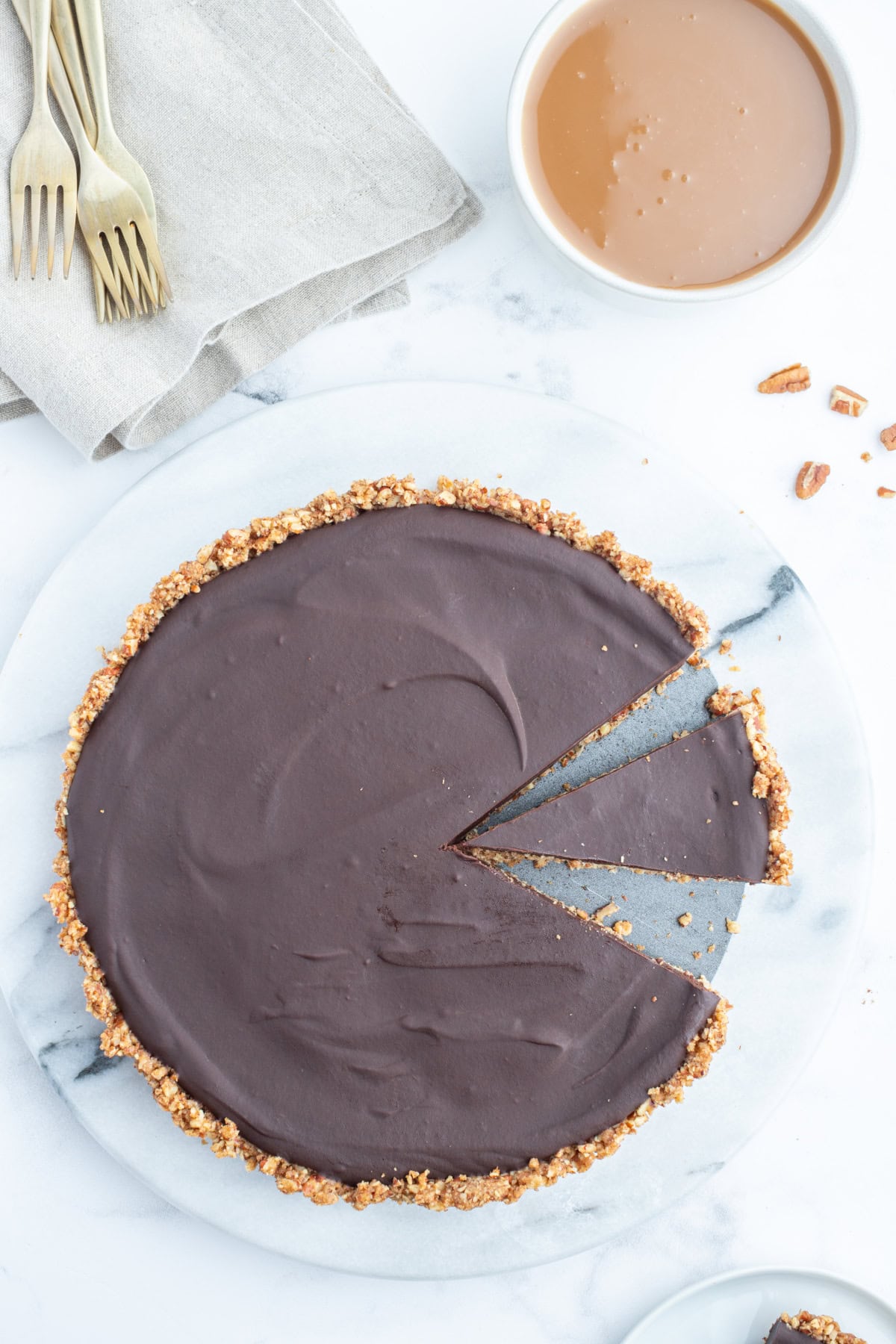 Chocolate Pecan Tart with Caramel Sauce recipe from RecipeGirl.com overhead shot of chocolate pecan tart with slice taken out