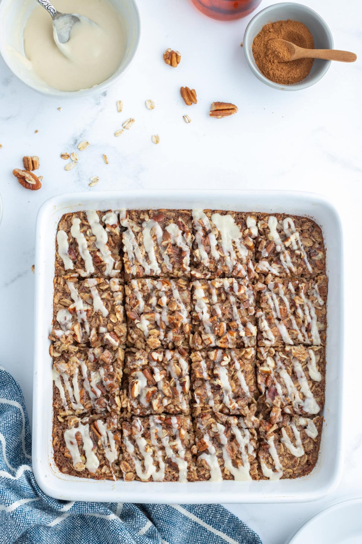 Cinnamon Roll Baked Oatmeal recipe from RecipeGirl.com cinnamon roll baked oatmeal in a baking dish cut into squares
