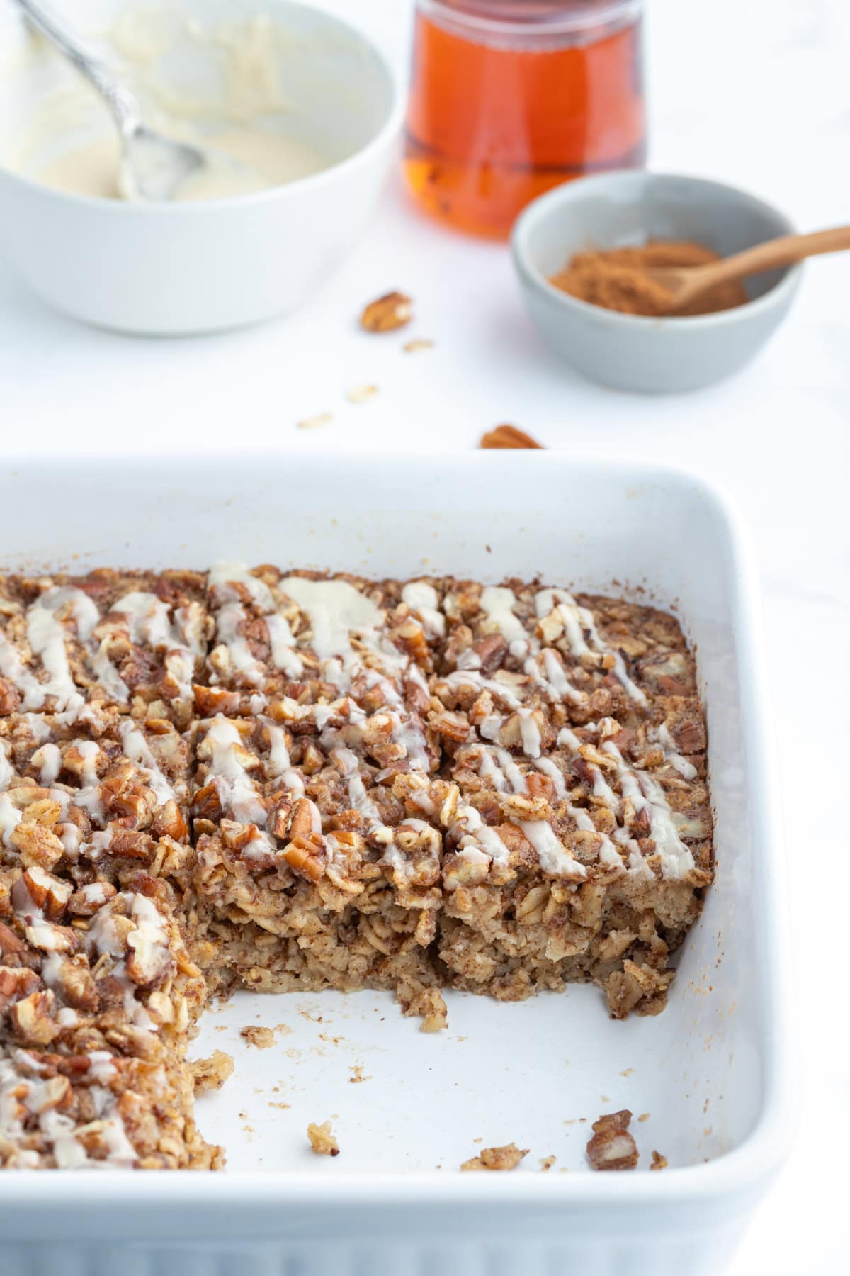 Cinnamon Roll Baked Oatmeal recipe from RecipeGirl.com cinnamon roll baked oatmeal in dish with slices taken out