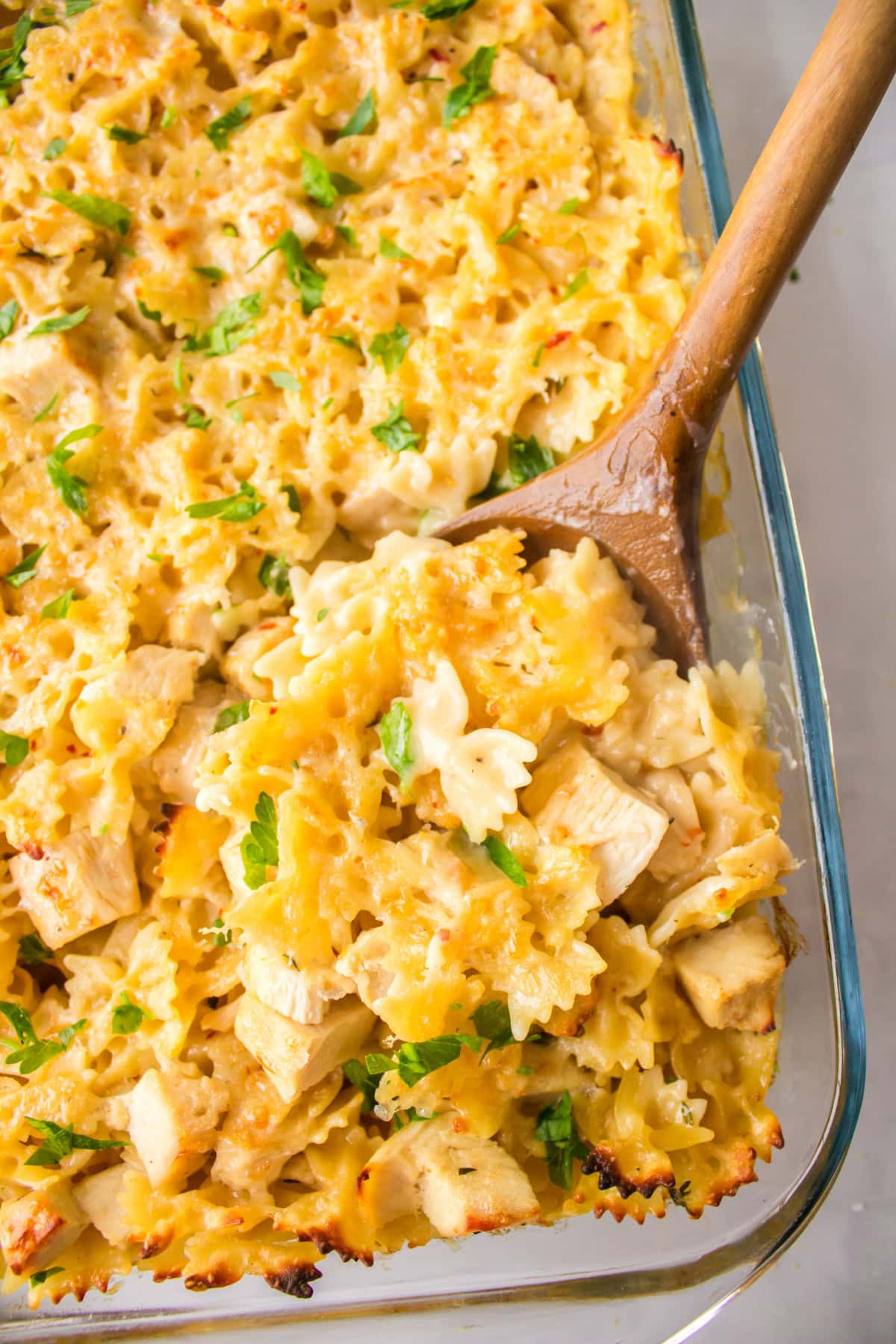 Creamy Lemon Chicken Pasta recipe from RecipeGirl.com wooden spoon in pan of creamy lemon chicken pasta