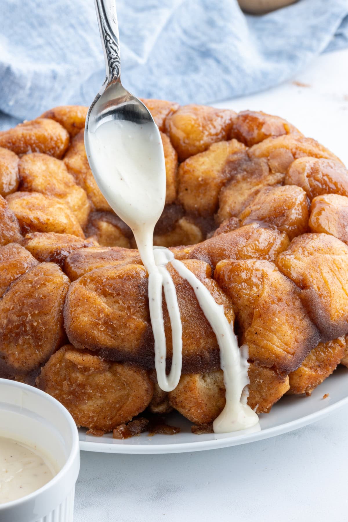 Eggnog Monkey Bread recipe from RecipeGirl.com drizzling icing onto eggnog monkey bread