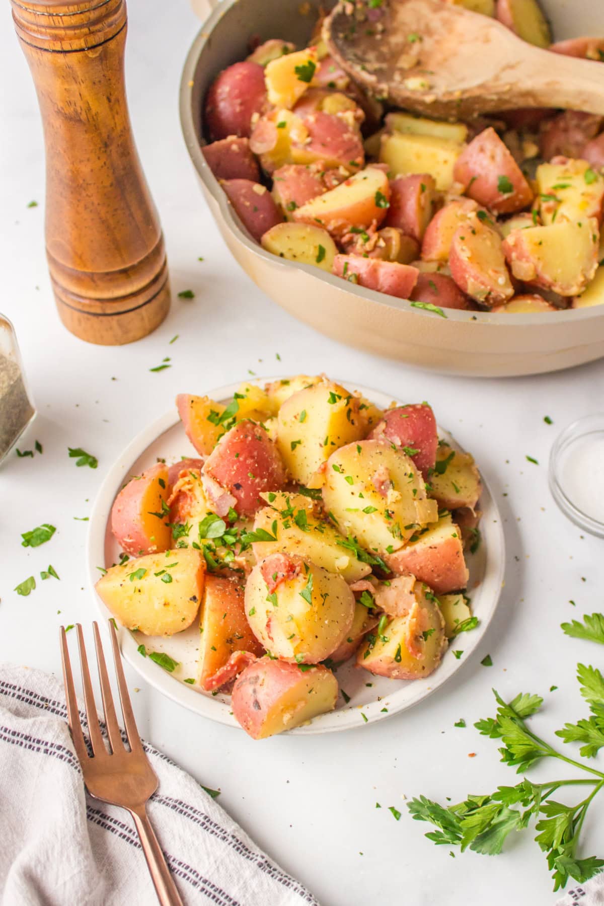 German Potato Salad recipe from RecipeGirl.com plate of german potato salad with whole salad in the background
