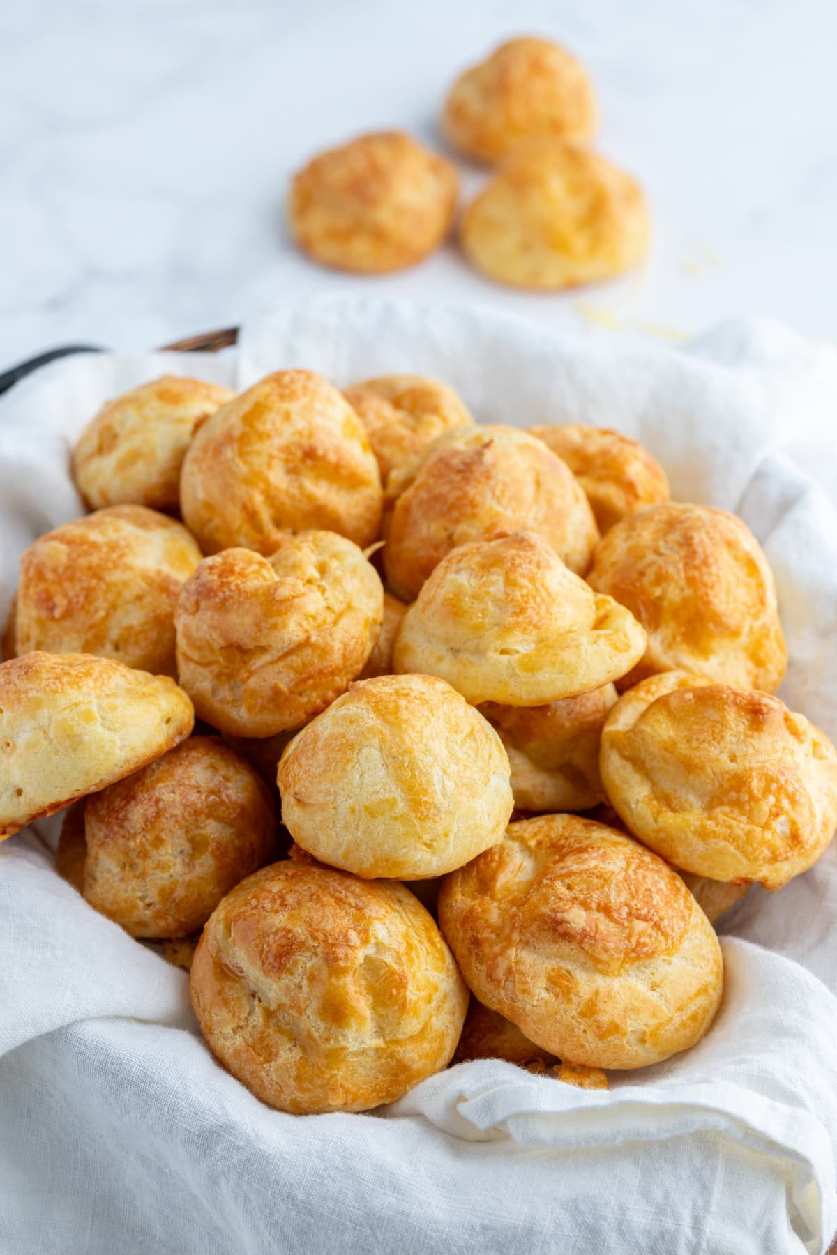 Gougeres French cheese puffs recipe from RecipeGirl.com gougeres in cloth lined basket