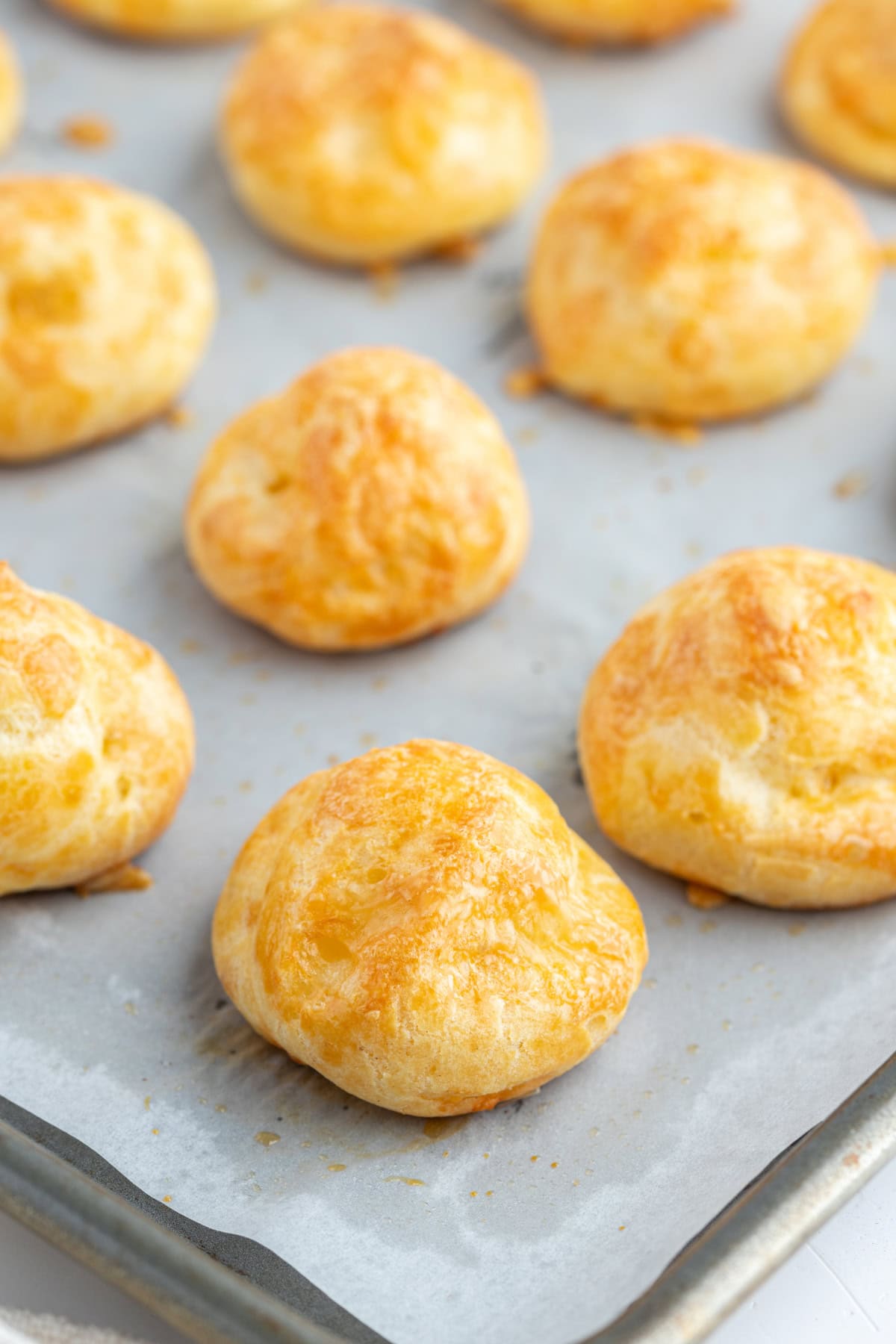 Gougeres French cheese puffs recipe from RecipeGirl.com gougeres on baking sheet close up