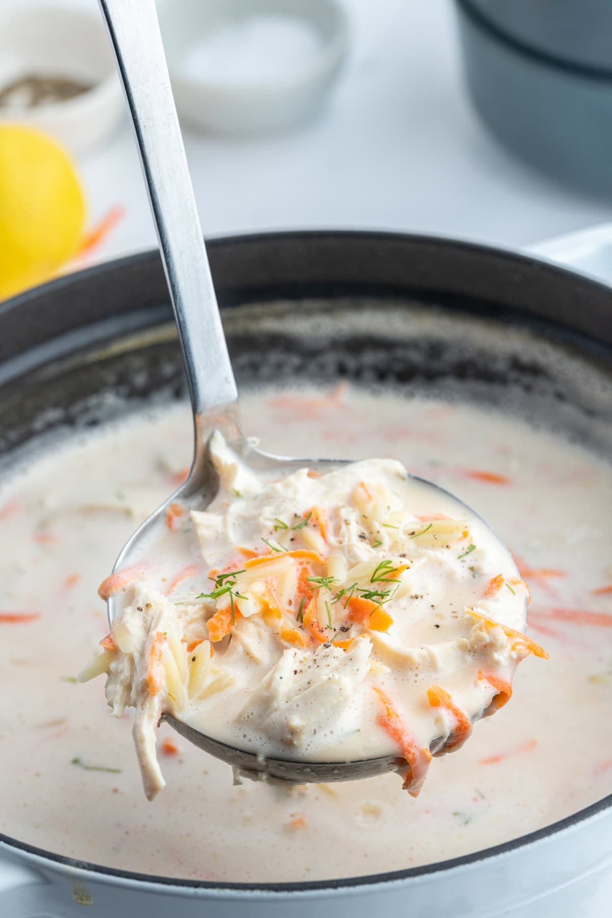 Greek Orzo and Chicken Soup recipe from RecipeGirl.com ladle full of greek orzo and chicken soup over pot of soup