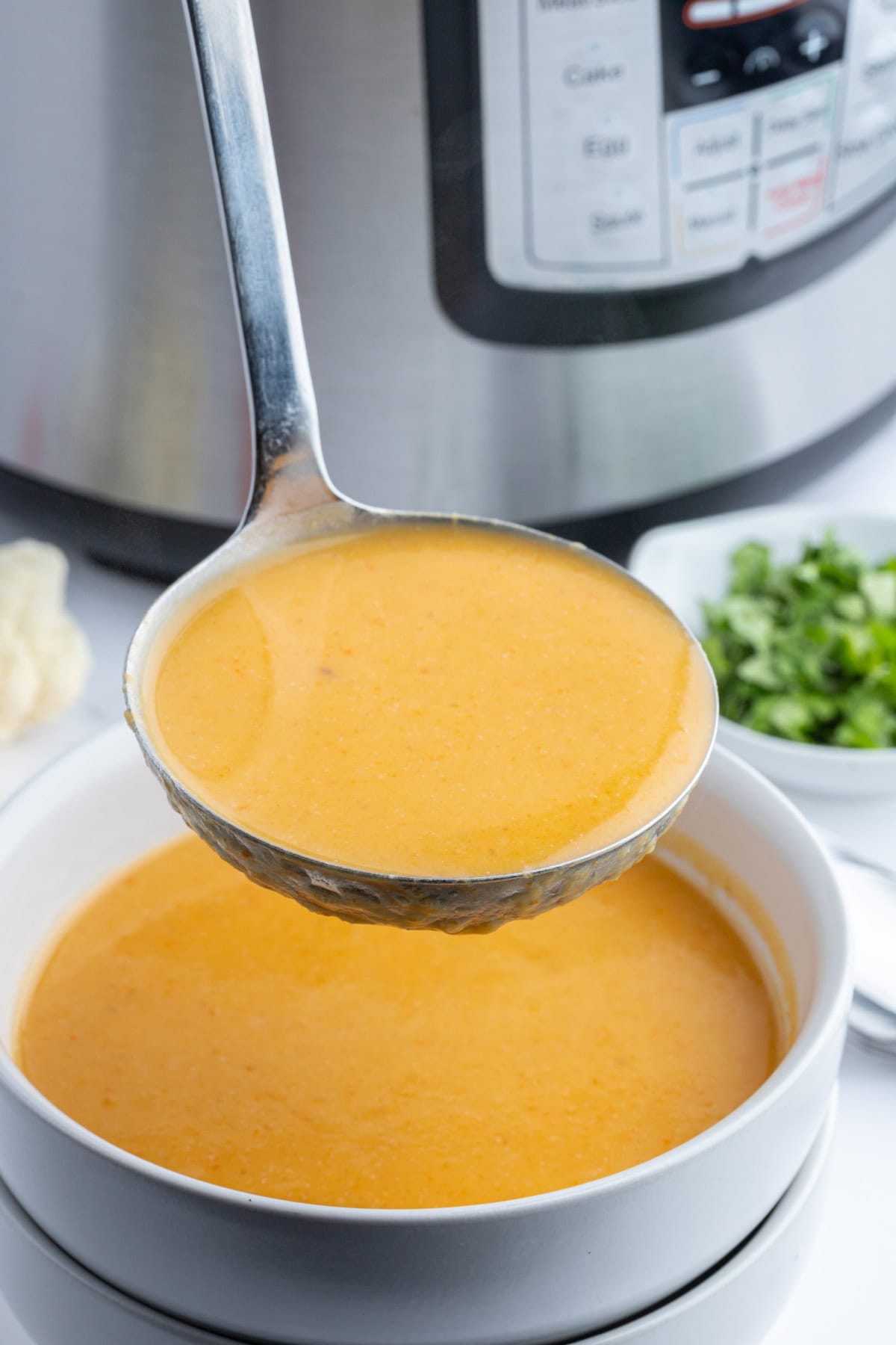 Instant Pot Cauliflower and Sweet Potato Soup recipe from RecipeGirl.com ladle full of cauliflower and sweet potato soup