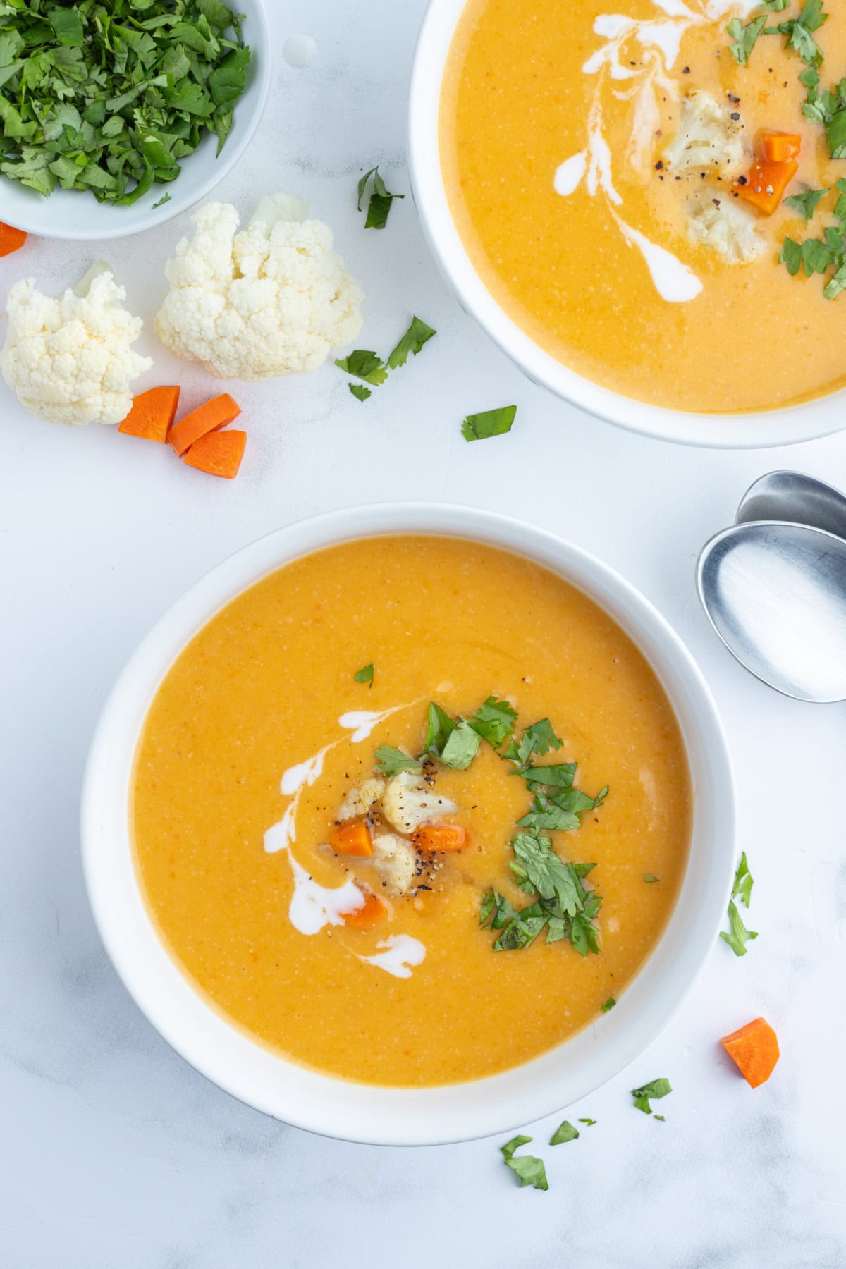 Instant Pot Cauliflower and Sweet Potato Soup recipe from RecipeGirl.com overhead shot of two bowls of cauliflower and sweet potato soup