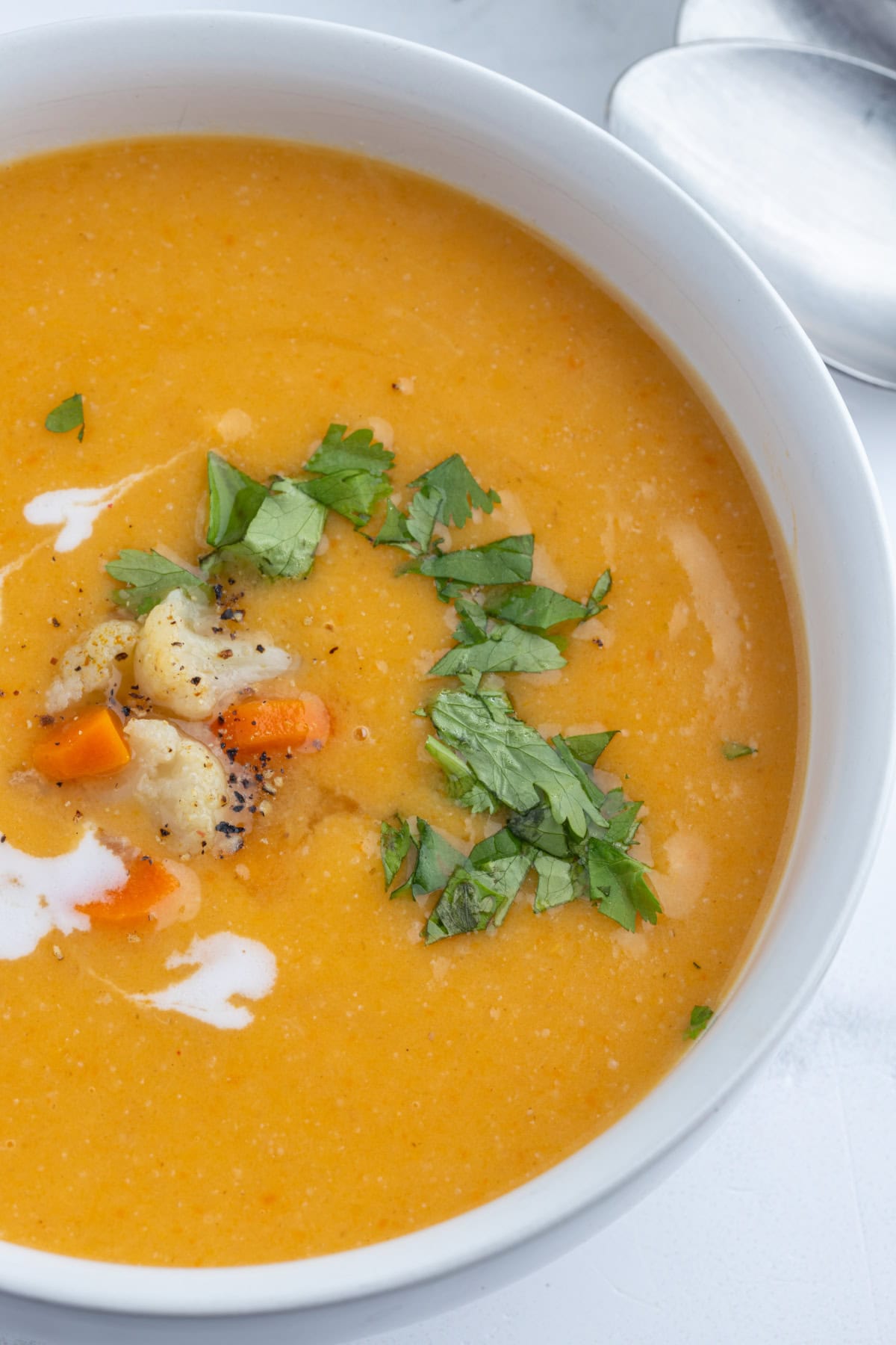 Instant Pot Cauliflower and Sweet Potato Soup recipe from RecipeGirl.com close up of bowl of instant pot cauliflower and sweet potato soup