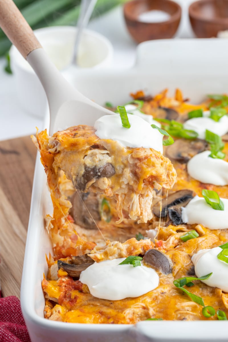 King Ranch Chicken Casserole recipe from RecipeGirl.com spooning king ranch chicken casserole out of casserole dish