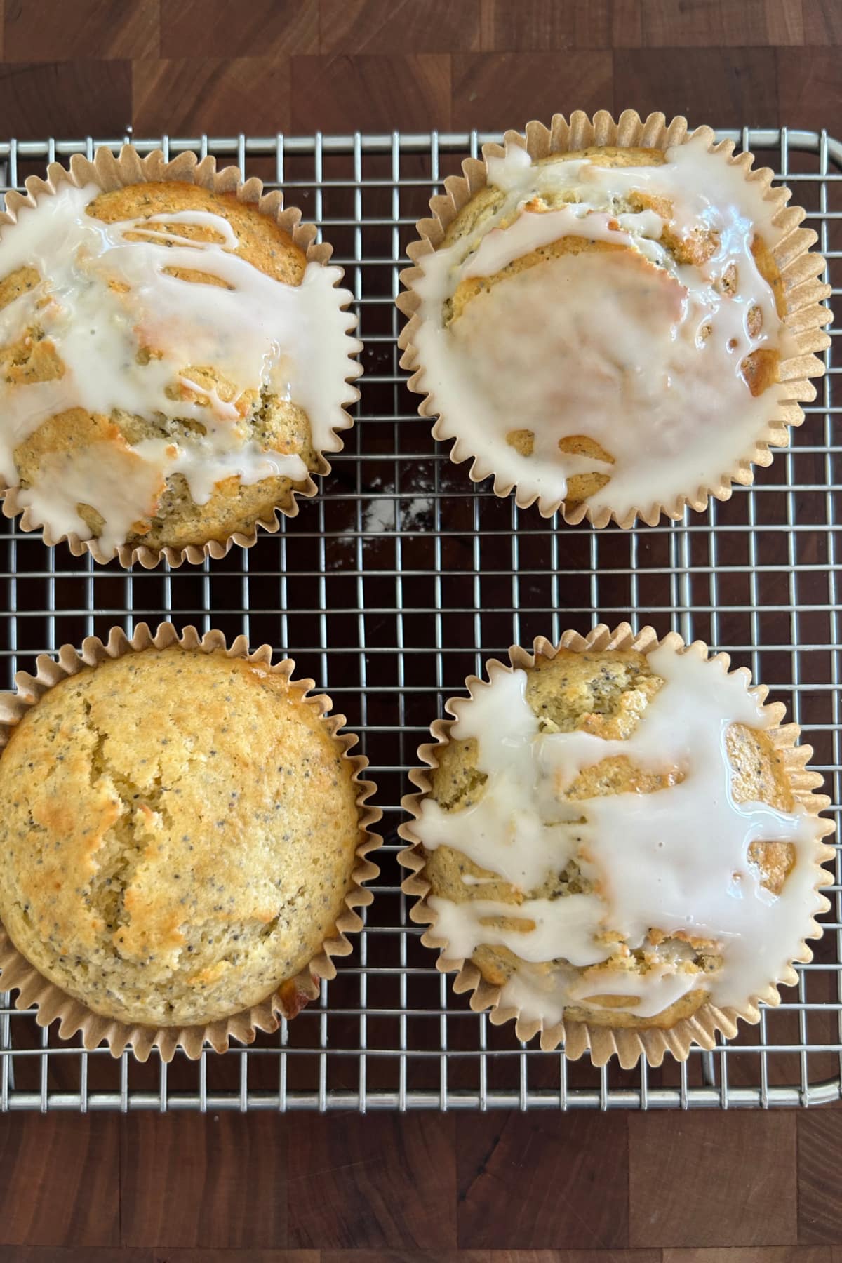 Lemon Poppy Seed Muffins recipe from RecipeGirl.com lemon poppy seed muffins on baking rack with some of them topped with glaze