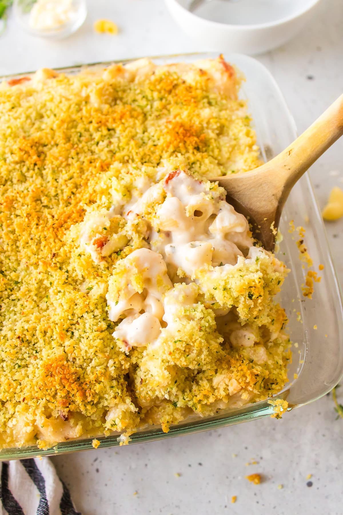 Macaroni and Cheese with Bacon recipe from RecipeGirl.com #macaroni #cheese #macaroniandcheese #bacon #recipe #RecipeGirl spooning bacon macaroni and cheese out of casserole dish