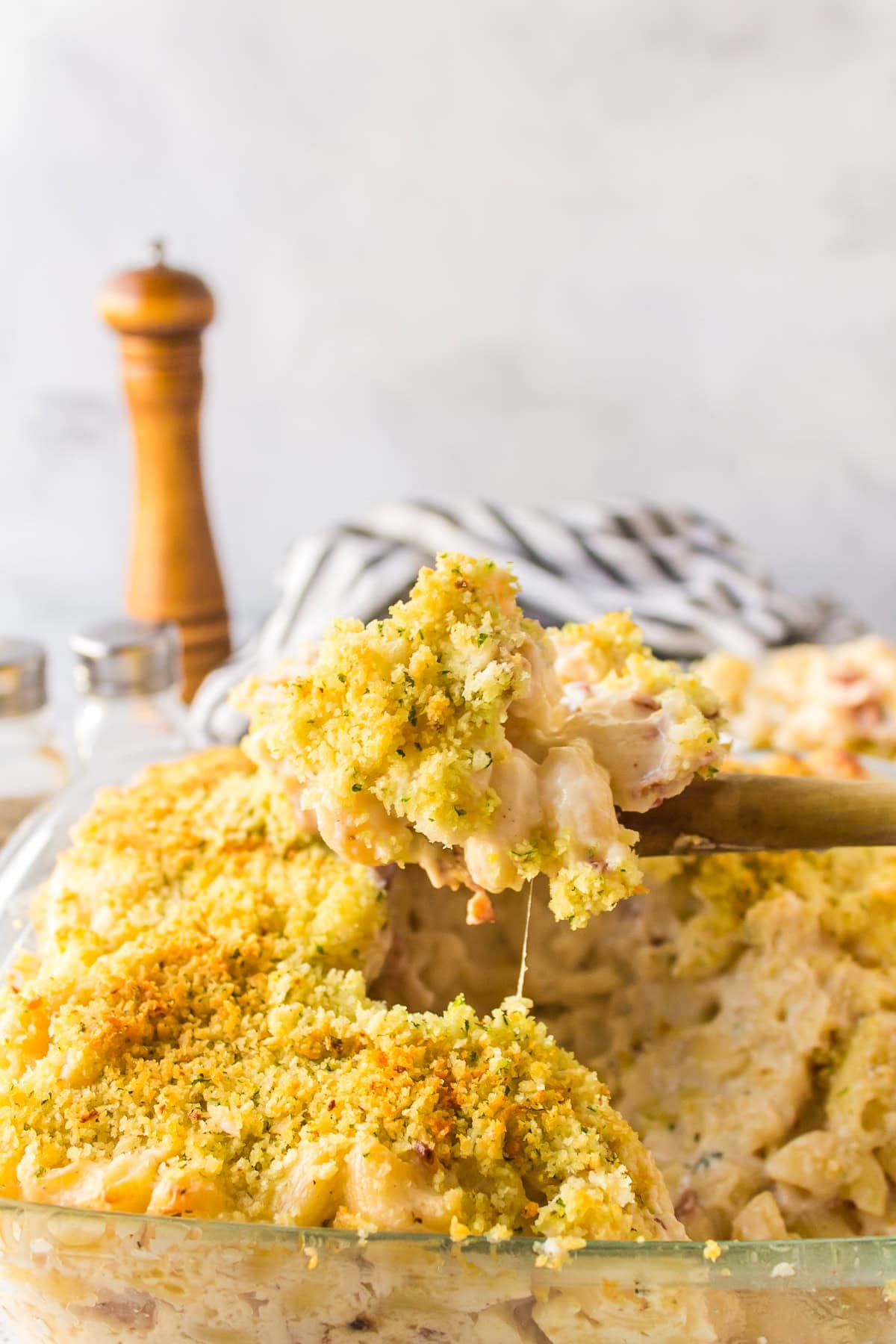 Macaroni and Cheese with Bacon recipe from RecipeGirl.com #macaroni #cheese #macaroniandcheese #bacon #recipe #RecipeGirl spoon lifting macaroni and cheese out of casserole dish