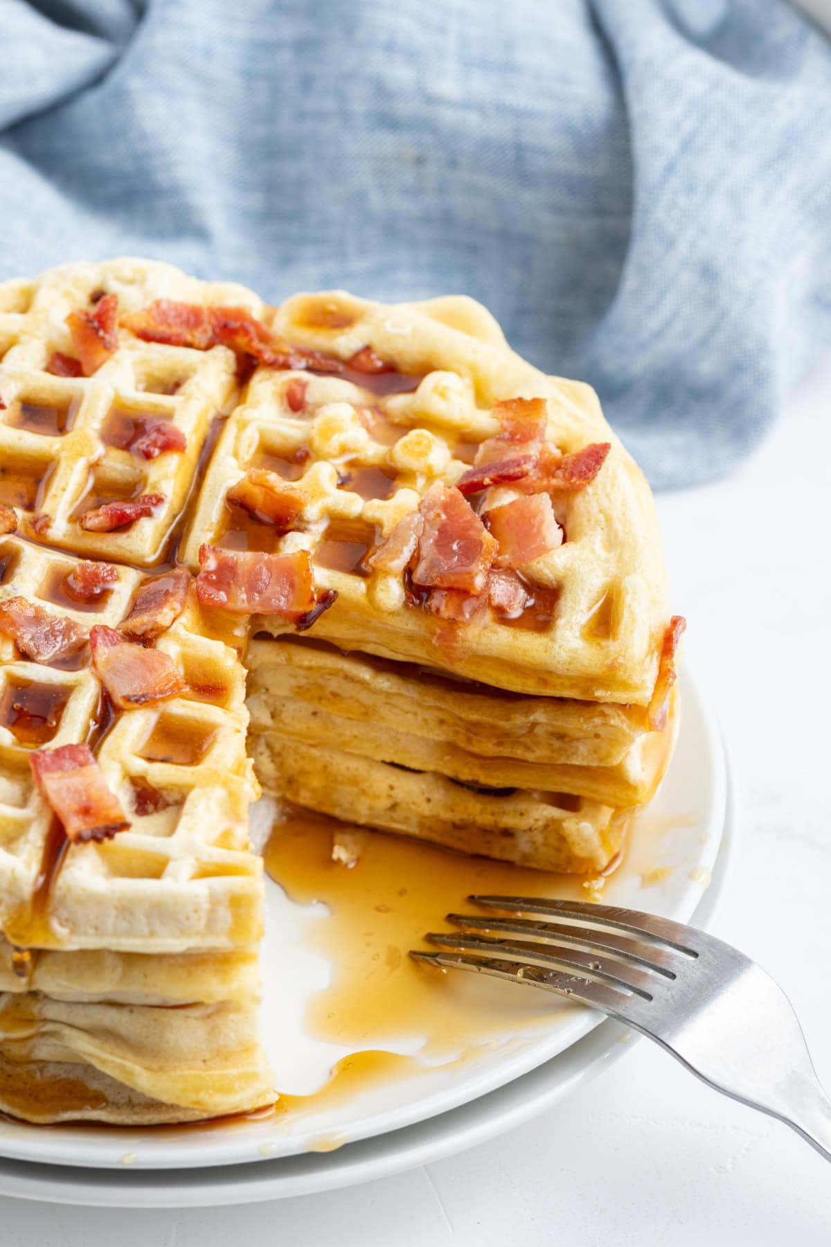 Maple Bacon Waffles recipe from RecipeGirl.com stack of maple bacon waffles with big slice taken out