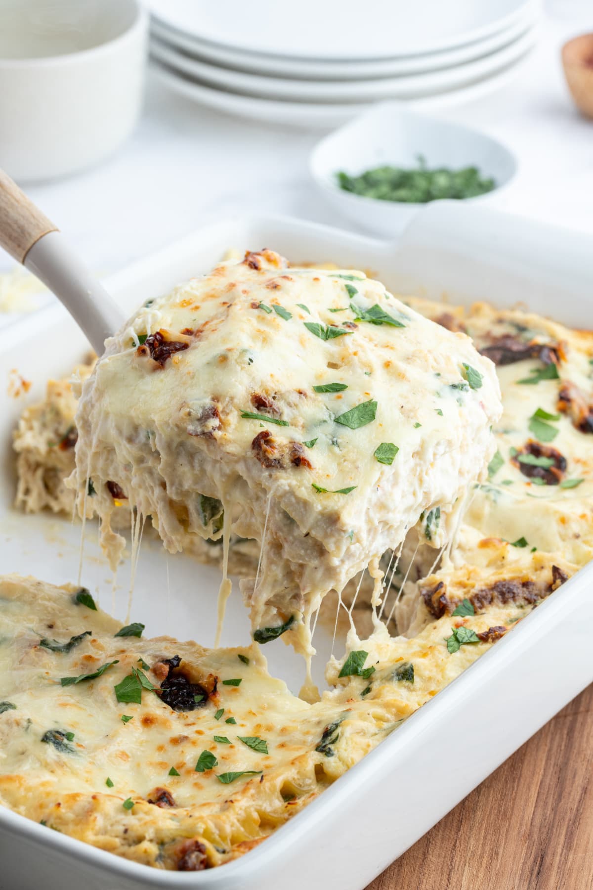 Marry Me Chicken Lasagna recipe from RecipeGirl.com marry me chicken lasagna with spatula taking slice out of dish