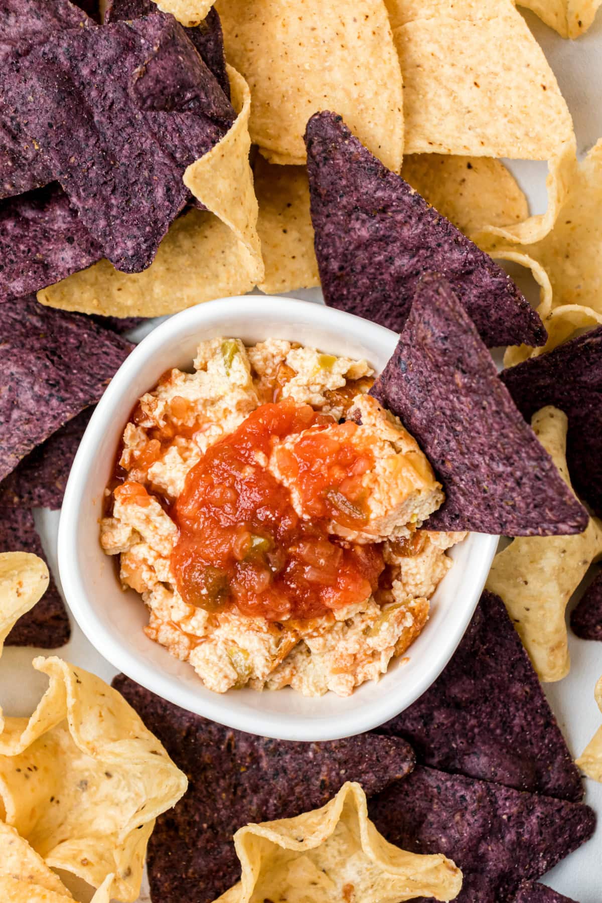 Mexican Cheesecake Dip recipe from RecipeGirl.com chip sitting in bowl of mexican cheesecake dip