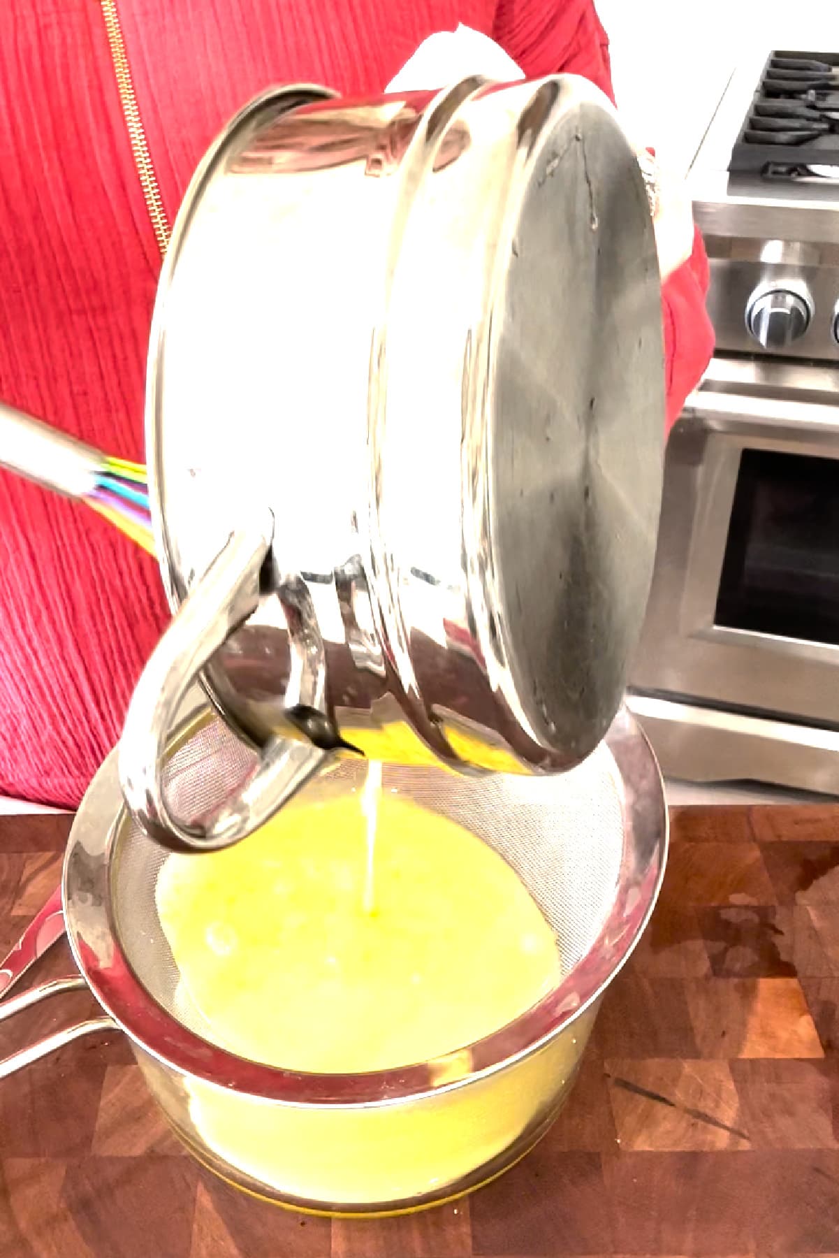Easy Meyer Lemon Curd recipe from RecipeGirl.com pouring lemon curd into fine mesh strainer