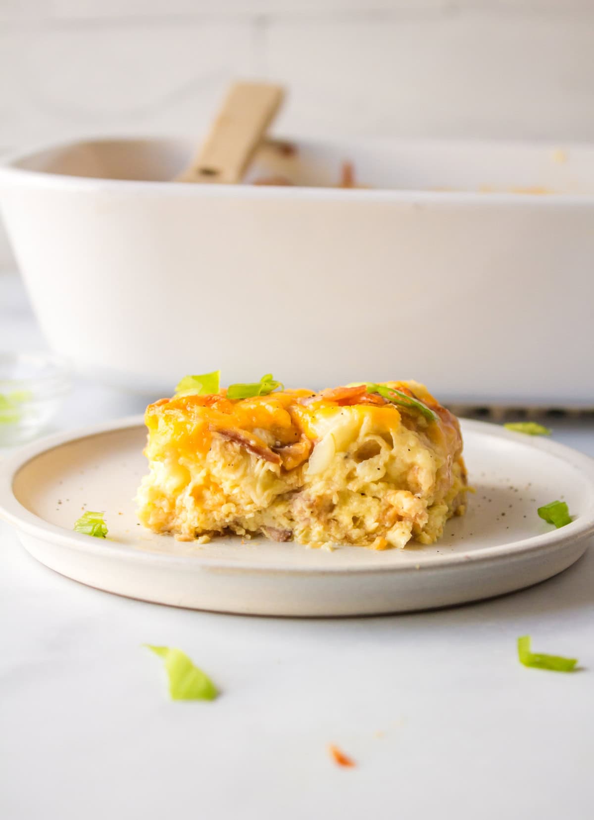 Overnight Croissant Ham and Cheese Breakfast Casserole recipe from RecipeGirl.com serving of overnight croissant ham and cheese breakfast casserole on plate