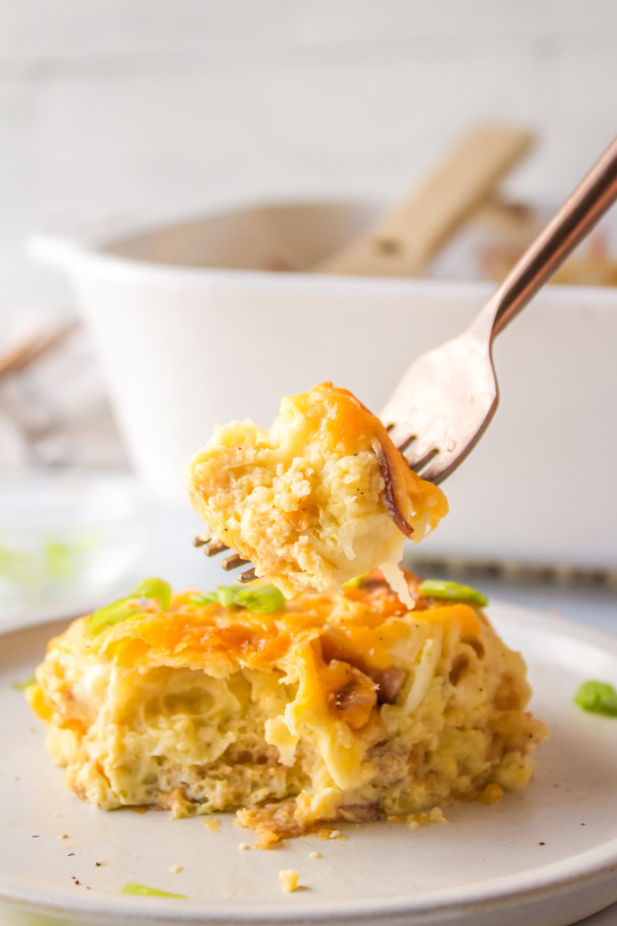 Overnight Croissant Ham and Cheese Breakfast Casserole recipe from RecipeGirl.com fork full of overnight croissant ham and cheese breakfast casserole