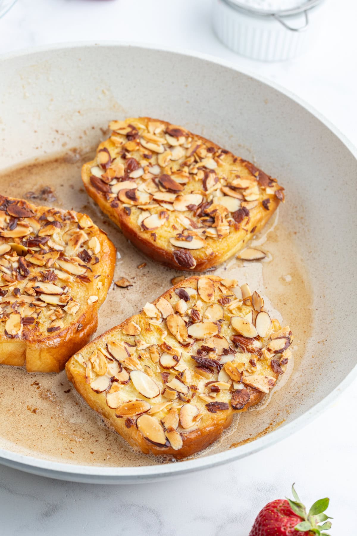 Pain Perdu is a traditional French toast. This is Ina Garten's Barefoot in Paris recipe with strawberries, almonds and Grand Marnier. pain perdu frying in pan
