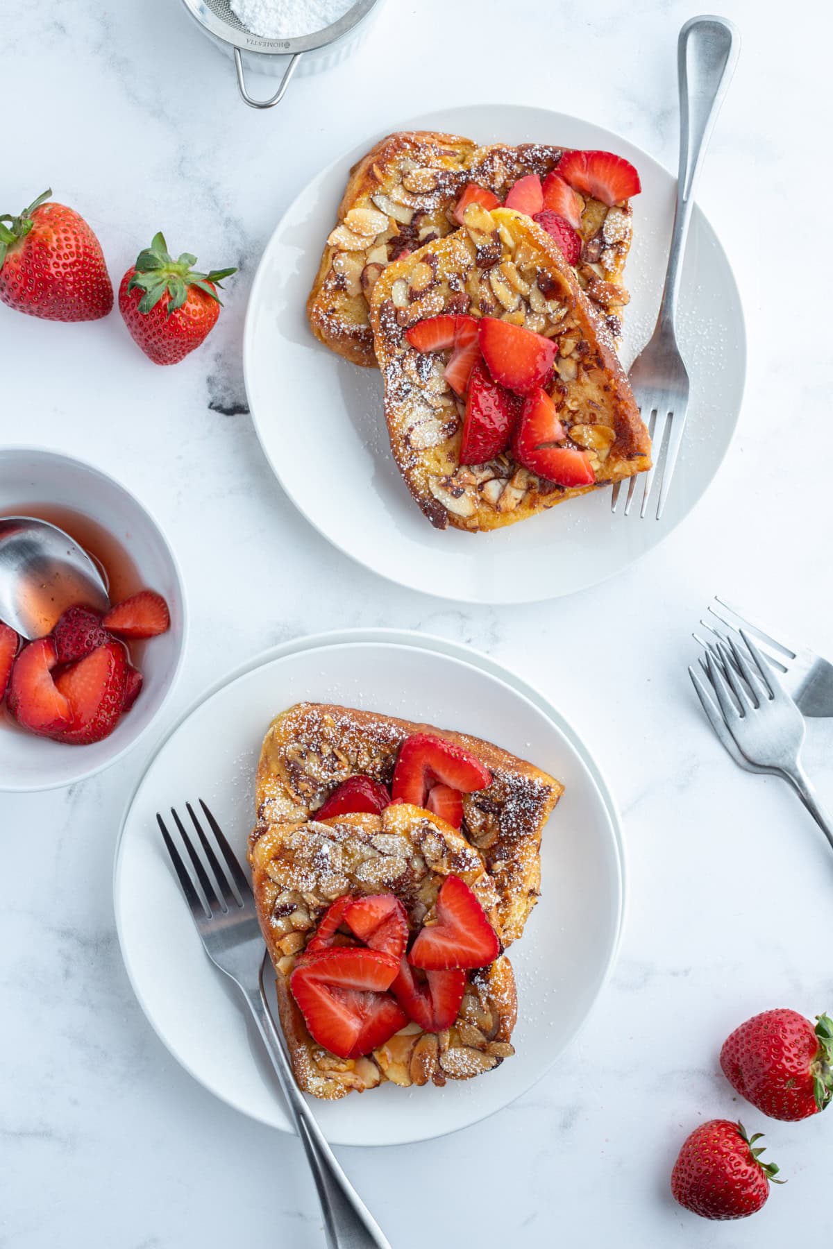 Pain Perdu is a traditional French toast. This is Ina Garten's Barefoot in Paris recipe with strawberries, almonds and Grand Marnier. two plates of pain perdu