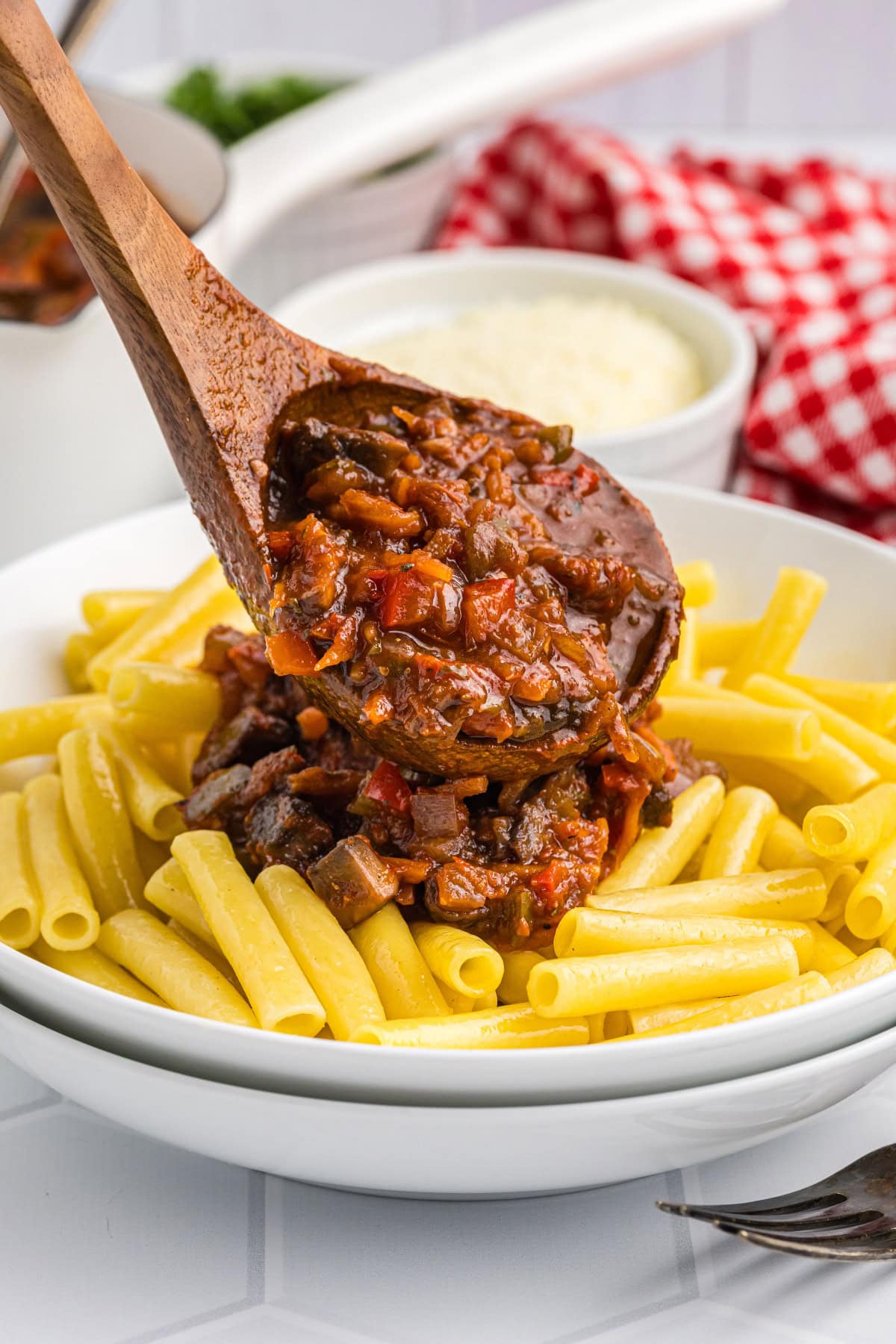 Pasta with Garden Bolognese recipe from RecipeGirl.com spooning bolognese sauce onto pasta