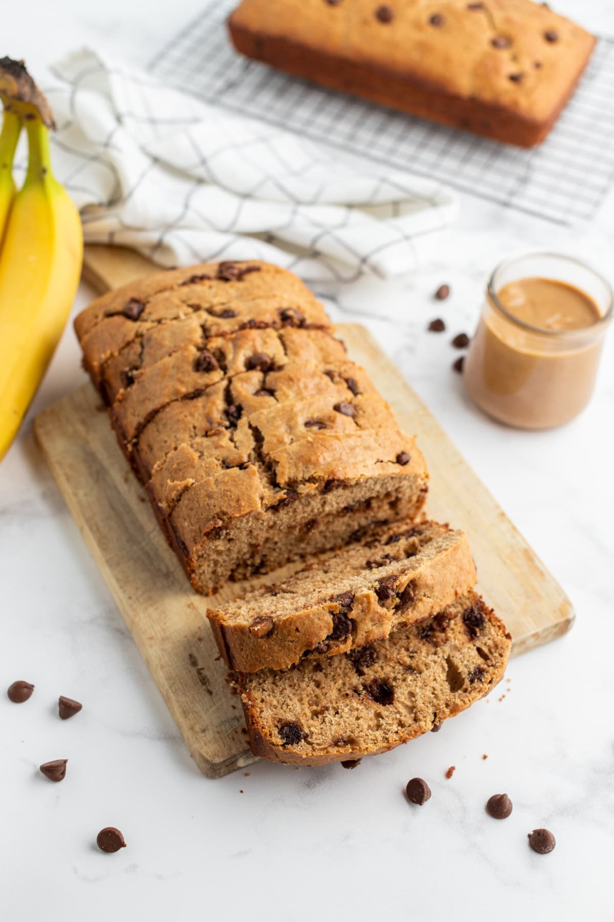 Peanut Butter Chocolate Chip Banana Bread recipe from RecipeGirl.com loaf of banana bread partially sliced on board