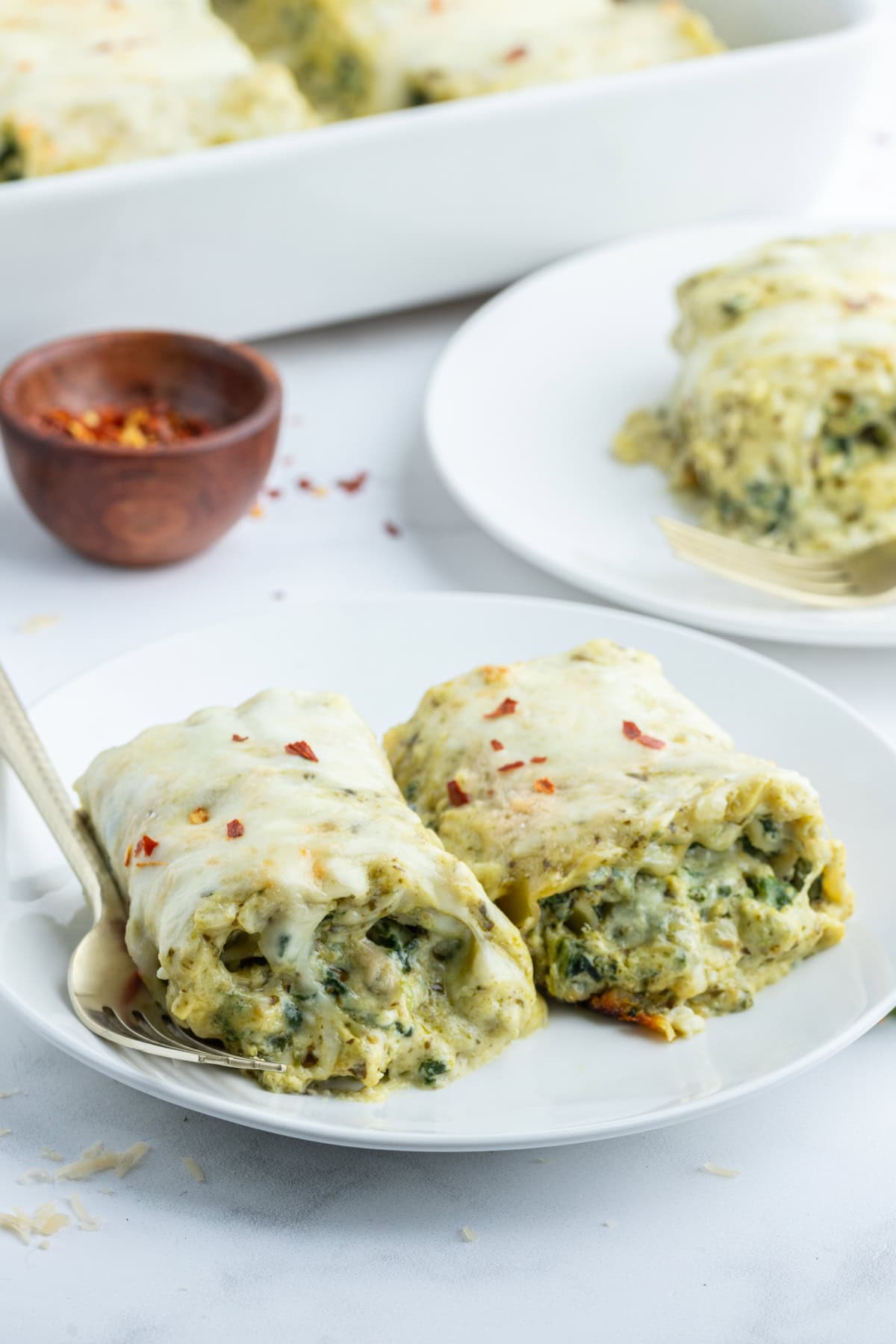 Pesto Lasagna Rolls recipe from RecipeGirl.com serving of pesto lasagna rolls on plate