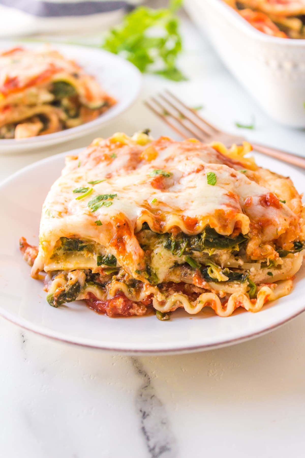 Spinach, Pesto and Cheese Lasagna recipe from RecipeGirl.com slice of lasagna on plate