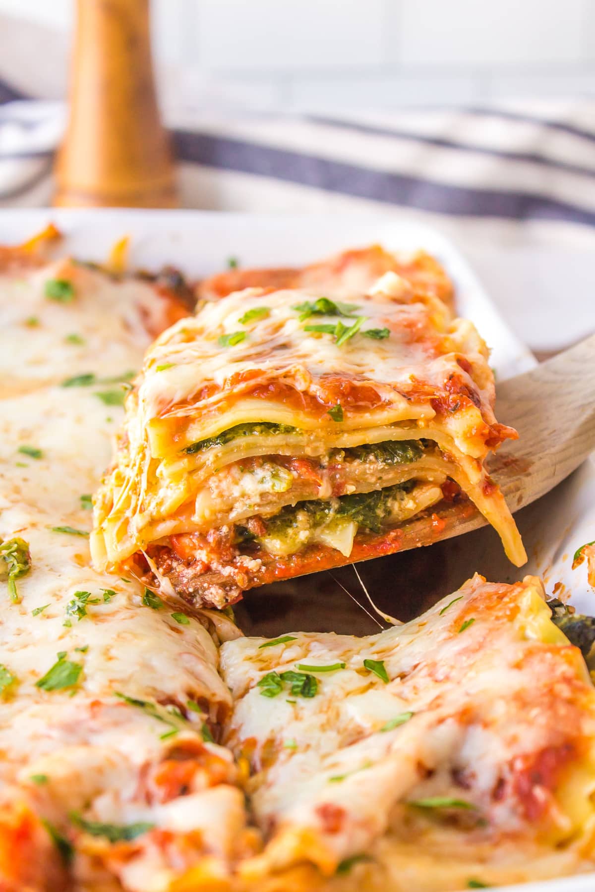 Spinach, Pesto and Cheese Lasagna recipe from RecipeGirl.com spatula taking slice of lasagna out of whole lasagna in pan