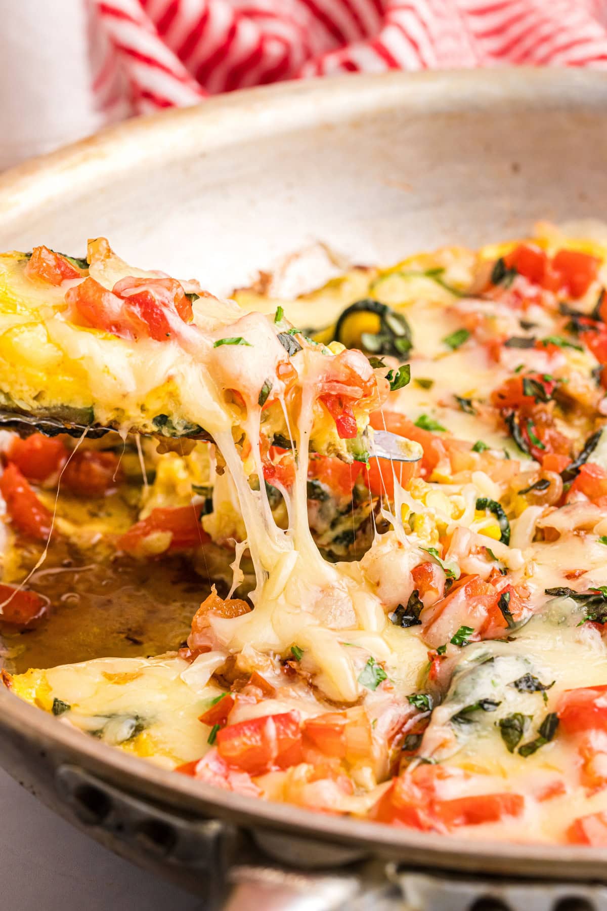 Squash and Tomato Oven Frittata recipe from RecipeGirl.com spatula picking up slice of squash and tomato oven frittata
