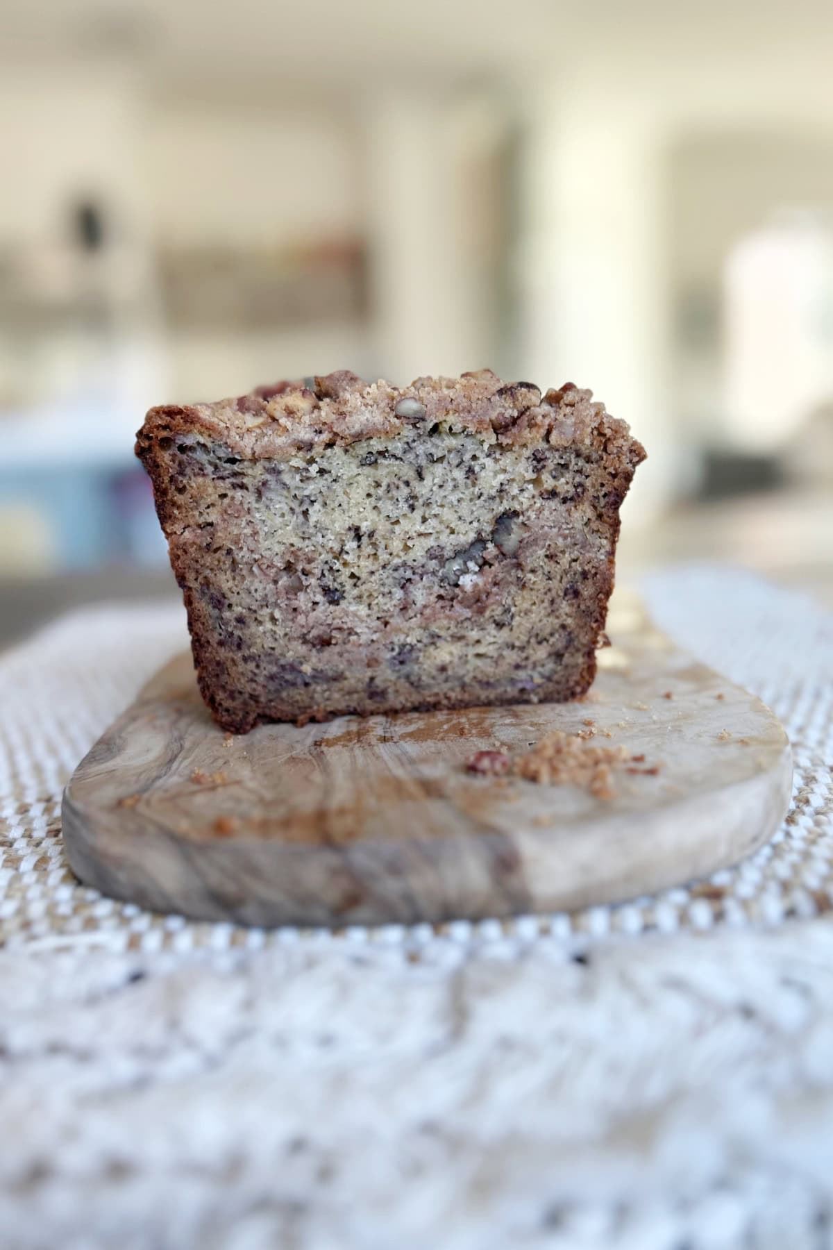 Streusel Banana Bread recipe from RecipeGirl.com banana bread loaf sliced open to see inside and sitting on board