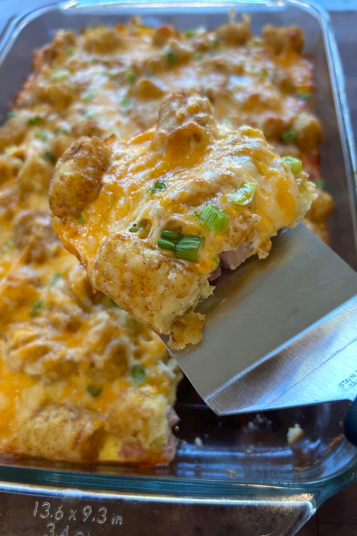 Tater Tot Breakfast Casserole recipe from RecipeGirl.com spatula taking out serving of tater tot breakfast casserole