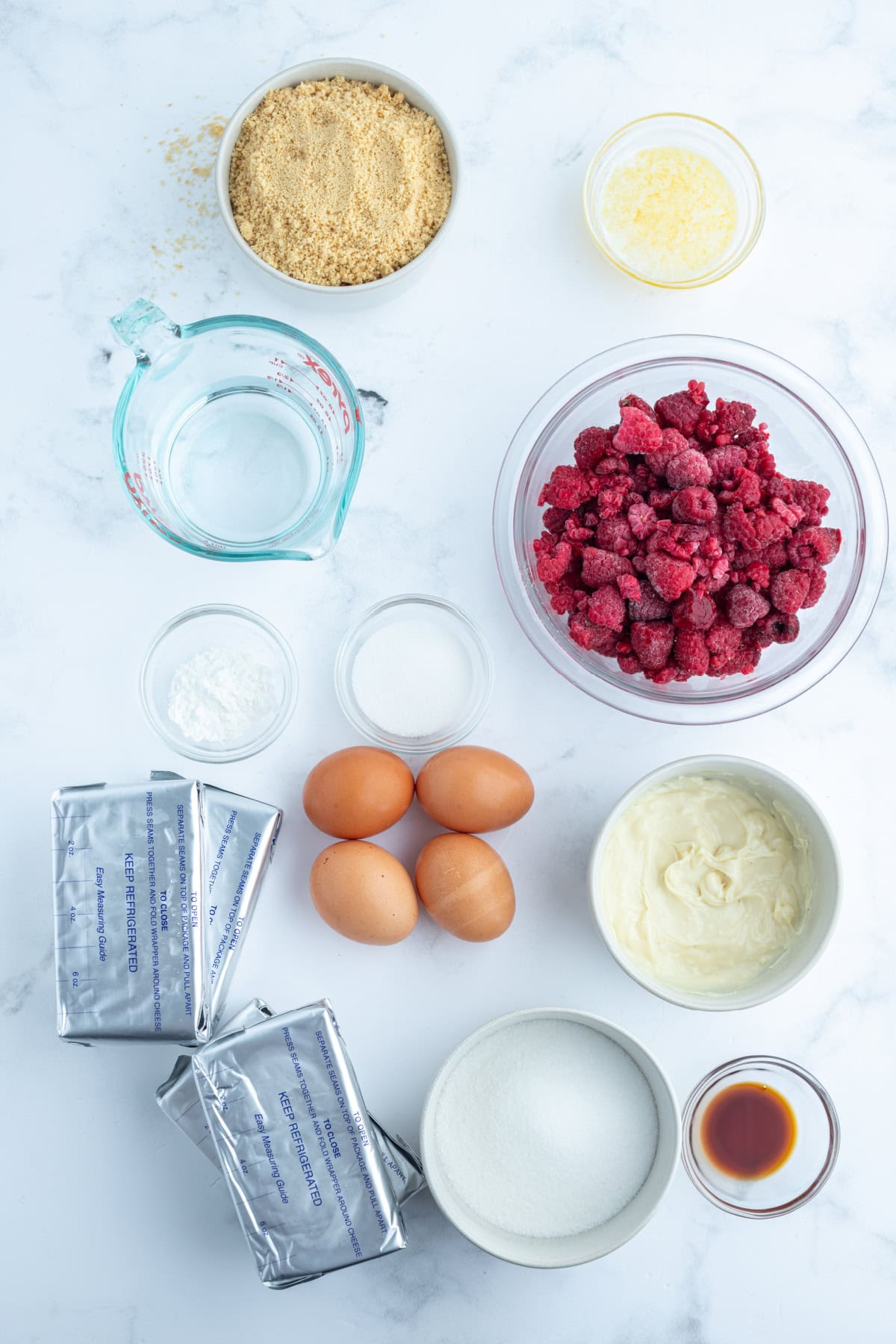 White Chocolate Raspberry Cheesecake recipe from RecipeGirl.com ingredients displayed for making white chocolate raspberry cheesecake